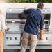 A man controlling the temperature of American Made Grills Encore 54-Inch Hybrid Grill