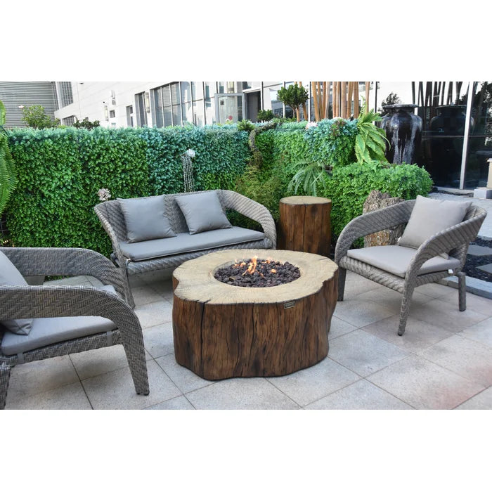 Elementi Manchester Concrete Fire Pit Table in an outdoor patio setting with wicker furniture